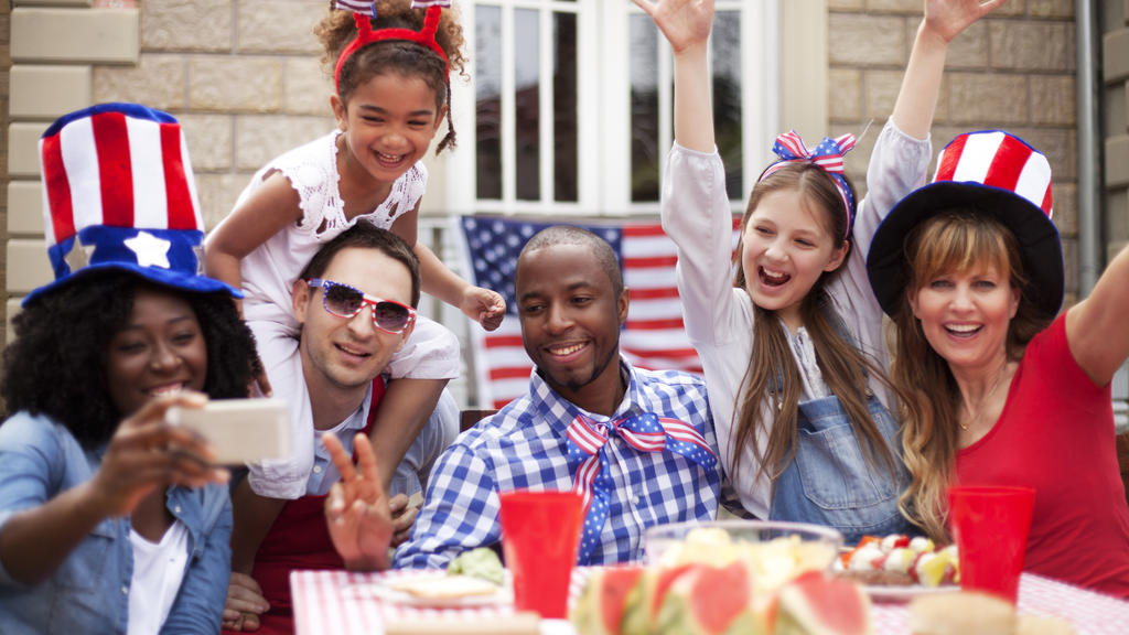 Zwei US-amerikanische Familien feiern im Garten den Nationalfeiertag "Fourth of July" in den USA.