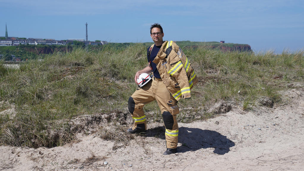 16.06.2021, Schleswig-Holstein, Helgoland: Felix Vorndran von der Freiwilligen Feuerwehr Bergisch-Gladbach steht an der Feuerwehrwache während seines Dünendienstes auf der Düne der Hochseeinsel Helgoland. Angenehmes mit dem Nützlichen verbinden könne
