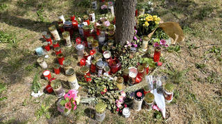 30.06.2021, Österreich, Wien: Kerzen und Blumen liegen am Fundort der Leiche eines erst 13 Jahre alten Mädchens. Nach dem Fund der Leiche eines 13-jährigen Mädchens in Wien hat die Polizei zwei Männer festgenommen. Die beiden Verdächtigen sind laut Behörden 16 und 18 Jahre alt. Foto: Herbert Neubauer/APA/dpa +++ dpa-Bildfunk +++