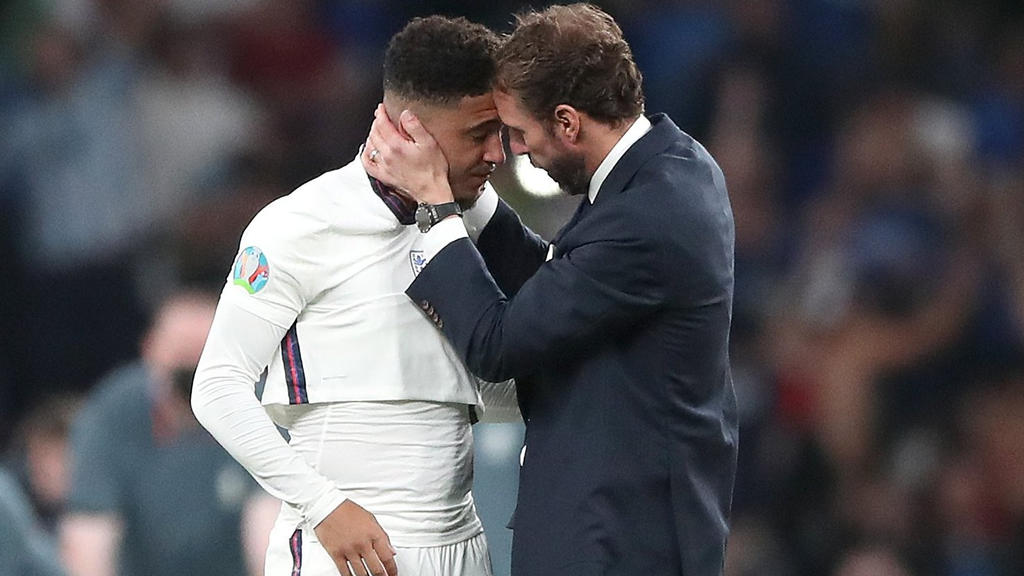 11.07.2021, Großbritannien, London: Fußball: EM, Italien - England, Finalrunde, Finale im Wembley Stadion. Englands Trainer Gareth Southgate tröstet Jadon Sancho nach der Niederlage im Elfmeterschießen . Italien gewinnt das Finale im Elfmeterschießen