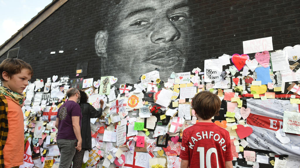 Soccer Football - Stand Up to Racism Demonstration at the Marcus Rashford mural after it was defaced following the Euro 2020 Final between Italy and England - Withington, Manchester, Britain - July 13, 2021 Benjamin Wheeler stands in front of the Mar