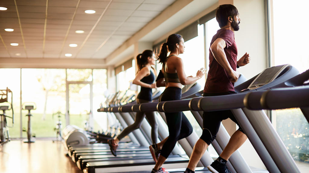 Menschen trainieren im Fitnessstudio auf dem Laufband