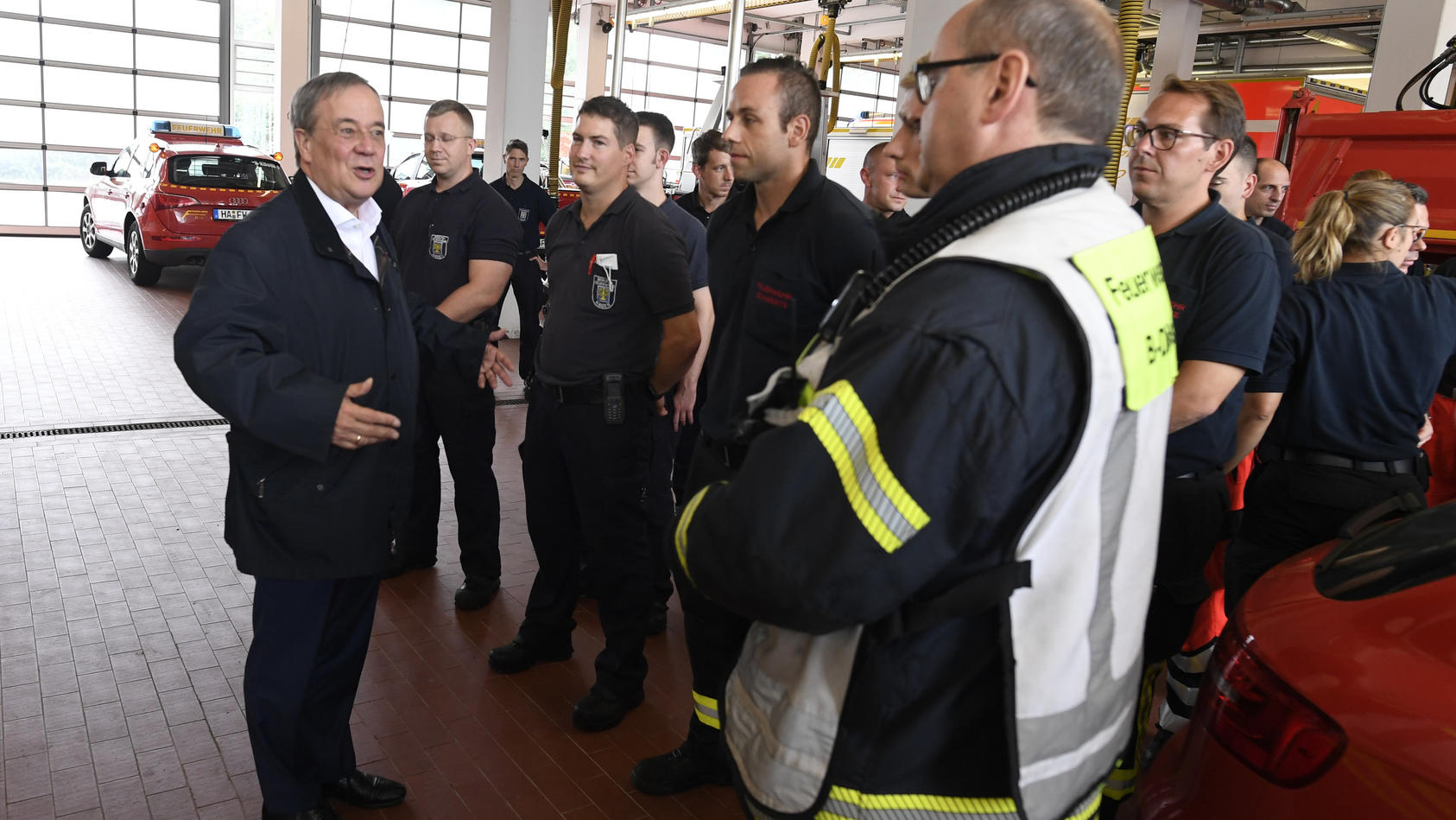 dpatopbilder - 15.07.2021, Nordrhein-Westfalen, Hagen: Der nordrhein-westfälische Ministerpräsident Armin Laschet (CDU, l) bedankt sich bei Hagenern Feuerwehrleuten für ihren Einsatz, nachdem er sich ein Bild von der Lage in der Stadt gemacht hat. St