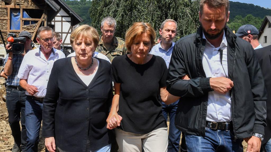 Malu Dreyer wird von Angela Merkel während einem langen Fußweg gestützt.