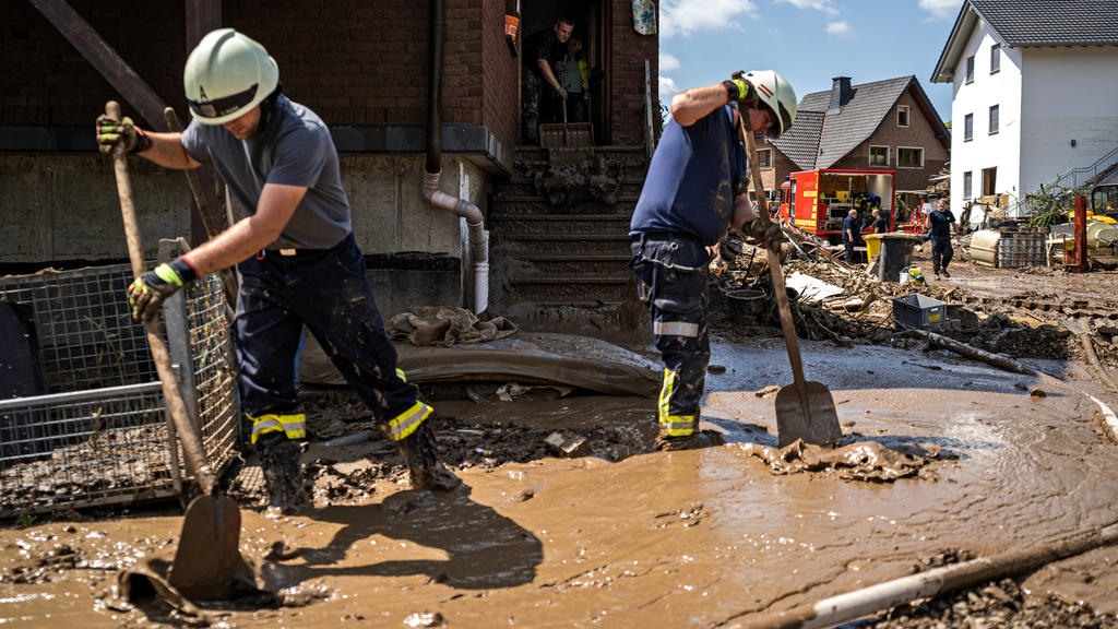 Aufräumarbeiten nach dem Hochwasser: Bewohner und Feuerwehr tragen Schlamm in der Stadt Marienthal ab.