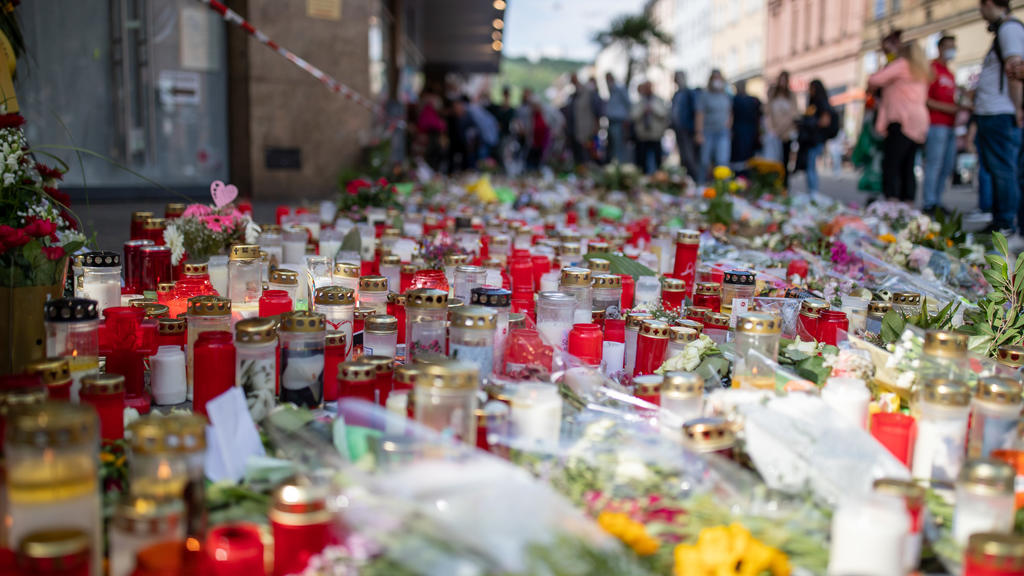 ARCHIV - 02.07.2021, Bayern, Würzburg: Grablichter, Kerzen und Blumen liegen vor einem Kaufhaus in der Innenstadt, in dem ein Mann am 25. Juni 2021 Menschen mit einem Messer attackiert und getötet hatte. Nun soll der Messerstecher in einer Psychiatri