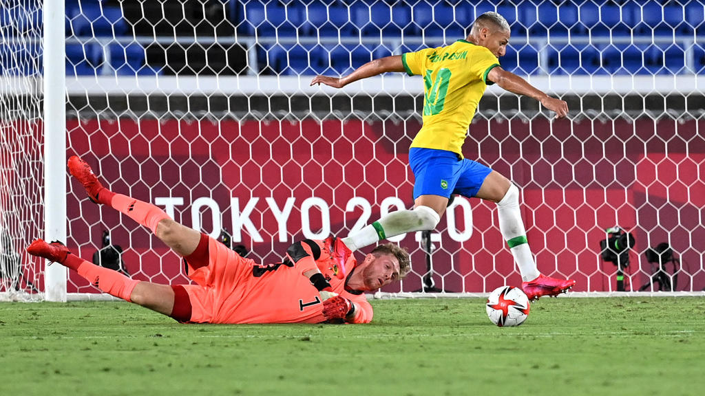 22.07.2021, China, Yokohama: Fußball: Olympia, Vorrunde, Gruppe D, 1. Spieltag, Brasilien - Deutschland im International Stadium Yokohama. Brasiliens Richarlison(r) und Torhüter Florian Müller. Foto: Guo Chen/XinHua/dpa +++ dpa-Bildfunk +++
