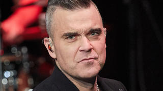 ARCHIV - 05.12.2019, Hamburg: Der Sänger Robbie Williams steht auf der Bühne im Kehrwieder Theater. Williams  hat sich erneut als Fan von Liverpool-Trainer J. Klopp gezeigt. «Er ist mein Männerschwarm. Ich liebe ihn ein bisschen», sagte der Brite der Deutschen Presse-Agentur. (zu dpa "Robbie Williams: «England geht es besser durch Klopp») Foto: Georg Wendt/dpa +++ dpa-Bildfunk +++