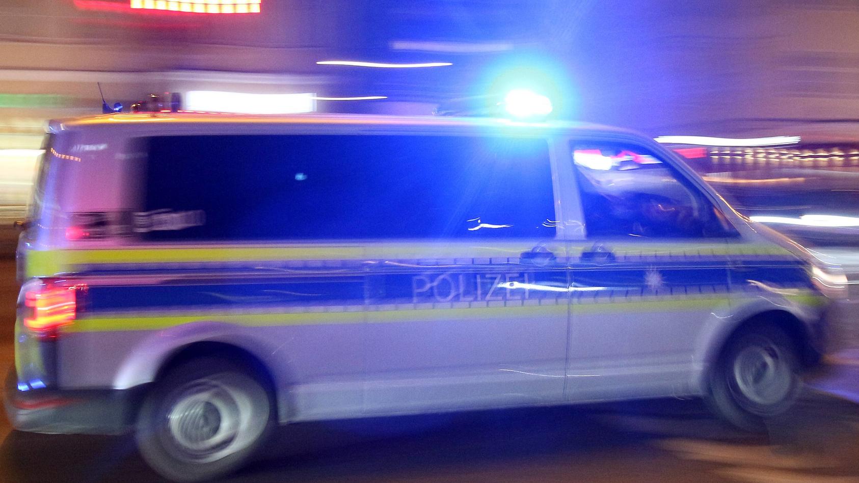 Einsatzwagen der Polizei mit eingeschaltetem Blaulicht bei einem Einsatz in München am Abend, Bayern, Deutschland *** Racing car of the police with the blue light on a mission in Munich on the night of Bavaria Germany  