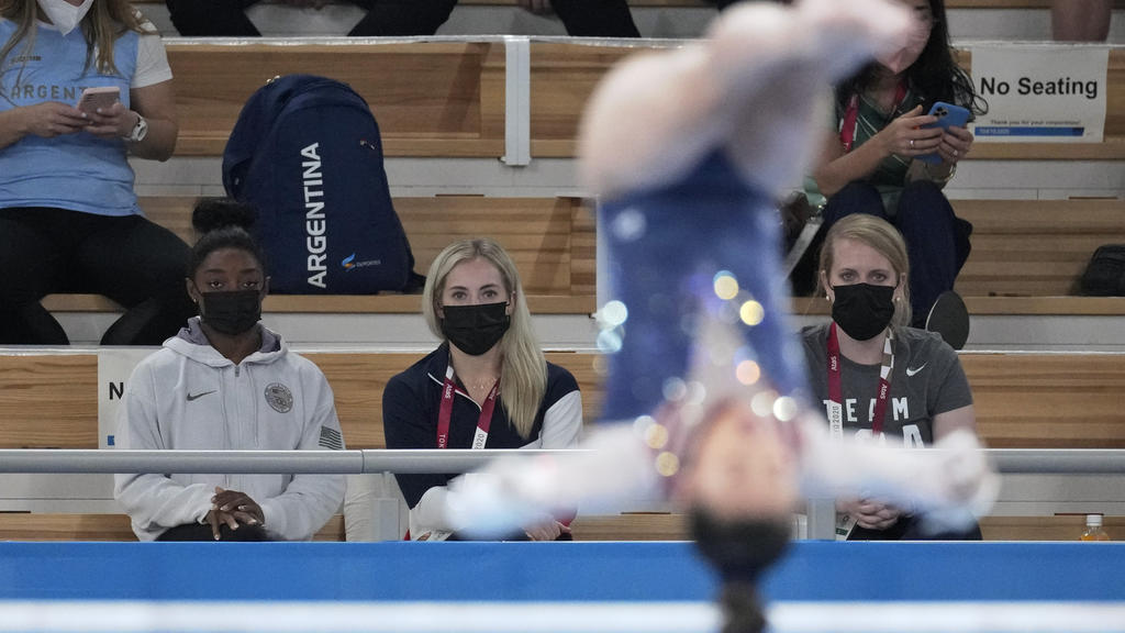 29.07.2021, Japan, Tokio: Turnen: Olympia, Mehrkampf, Frauen, Finale im Ariake Gymnastics Centre. Turnerin Simone Biles aus den USA (l) sieht ihrer Teamkollegin Sunisa Lee am Stufenbarren zu. Foto: Ashley Landis/AP/dpa +++ dpa-Bildfunk +++
