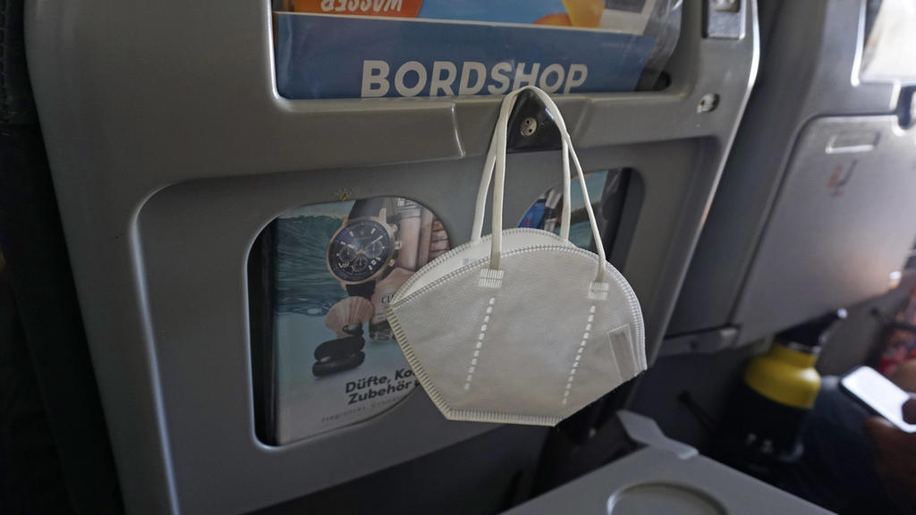 20.07.2021, Reisen und Fliegen in Zeiten der Corona-Pandemie, eine FFP2-Maske hängt an der Lehne eines Passagier-Flugzeuges. 20.07.2021, Urlaubsreisen Mallorca nach Corona 20.07.2021, Urlaubsreisen Mallorca nach Corona *** 20 07 2021, Traveling and f