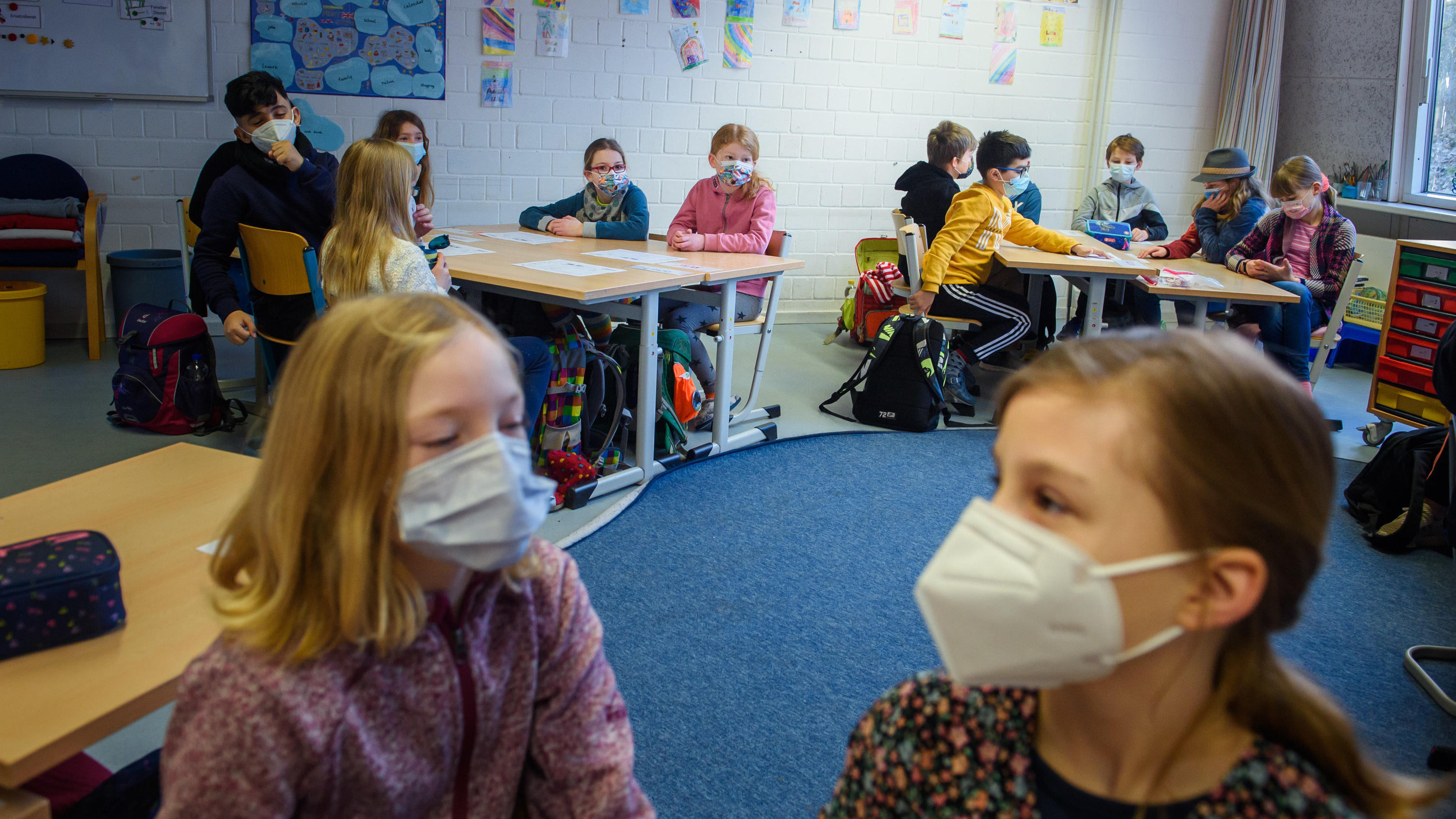 Schüler und Schülerinnen einer 4. Klasse sitzen im Unterricht an der Grundschule Russee in Kiel zusammen an einem Tisch und tragen dabei einen Mund-Nasen-Schutz. Trotz weiterhin verschärfter Kontaktbeschränkungen