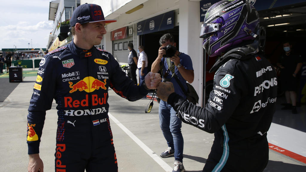 Mercedes driver Lewis Hamilton of Britain, right, after setting a pole position fist bumps with third placed Red Bull driver Max Verstappen of the Netherlands after the qualifying session for the Hungarian Formula One Grand Prix, at the Hungaroring r