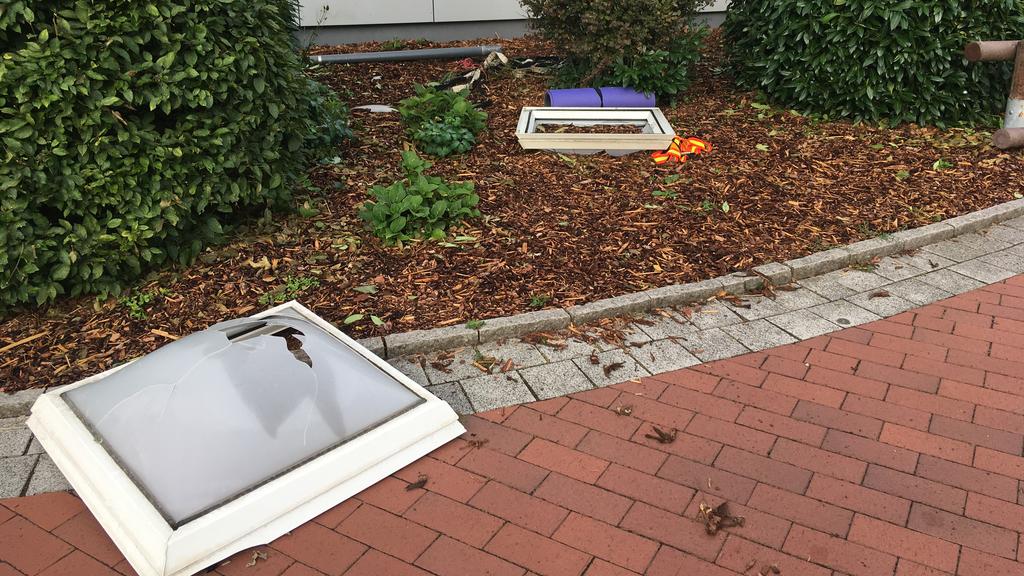 Die kaputten Oberlichter liegen im Vorgarten der Turnhalle.