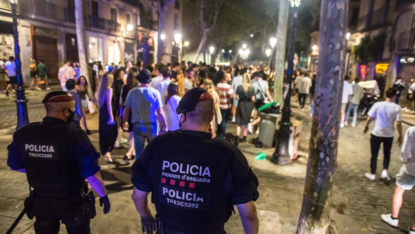 11.07.2021, Spanien, Barcelona: Polizisten vertreiben junge Menschen, die sich nachts auf der Straße versammelt hatten. Zur Eindämmung der schon seit Tagen rasant steigenden Infektionszahlen schränkt der spanische Corona-Hotspot Katalonien nächtliche