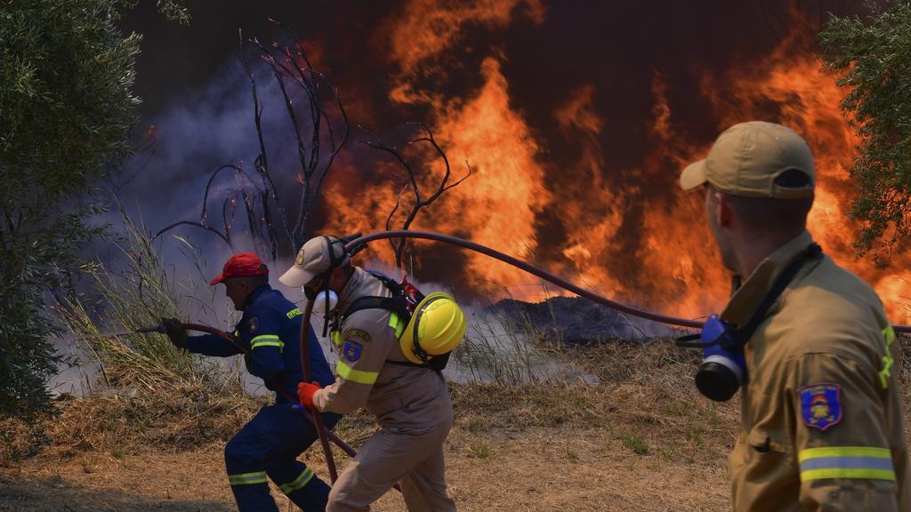 Griechenland, Olympia: Feuerwehrleute bekämpfen einen Waldbrand in der Nähe der Stadt Olympia. Einsatzkräfte sind nach wie vor im Einsatz und bekämpfen Waldbrände. Das Feuer nördlich von Athen ist erneut voll aufgeflammt. Foto: Giannis Sp