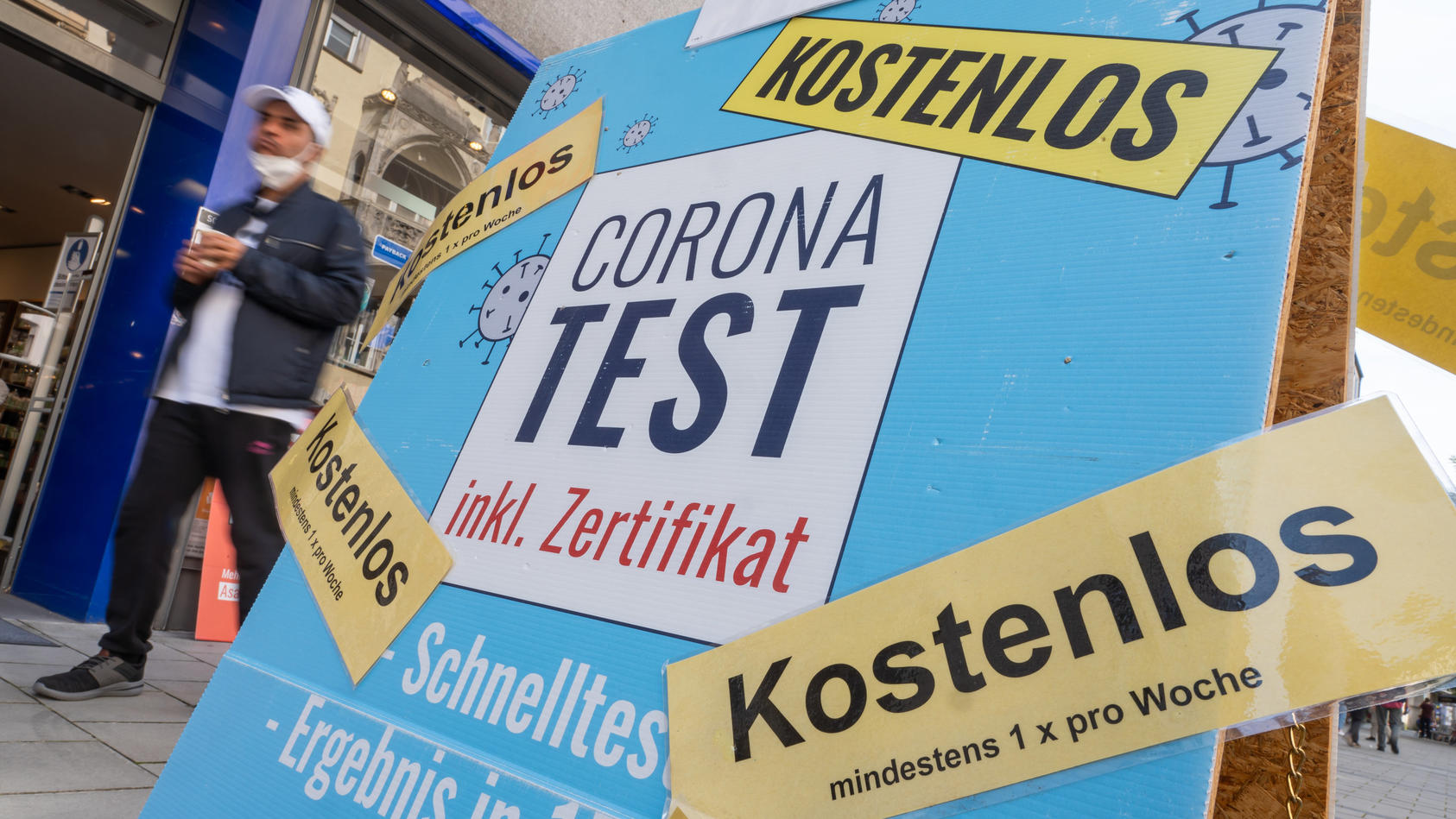 09.08.2021, Bayern, München: Ein Passant geht in der Fußgängerzone der Innenstadt an einer Apotheke vorbei, in der kostenlose Corona-Tests angeboten werden. Foto: Peter Kneffel/dpa +++ dpa-Bildfunk +++