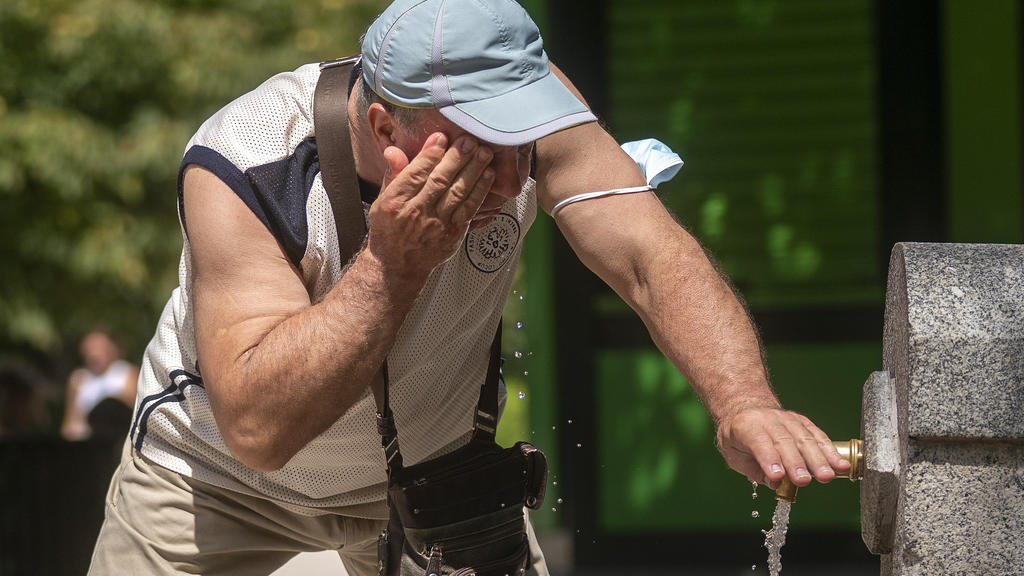 12.08.2021, Spanien, Madrid: Ein Mann versucht, sich in einem Brunnen im Retiro-Park in Madrid abzukühlen. In Spanien warnte der nationale Wetterdienst vor Temperaturen in den kommenden Tagen von bis zu 44 Grad Celsius. Für Teile des Nordostens Spani