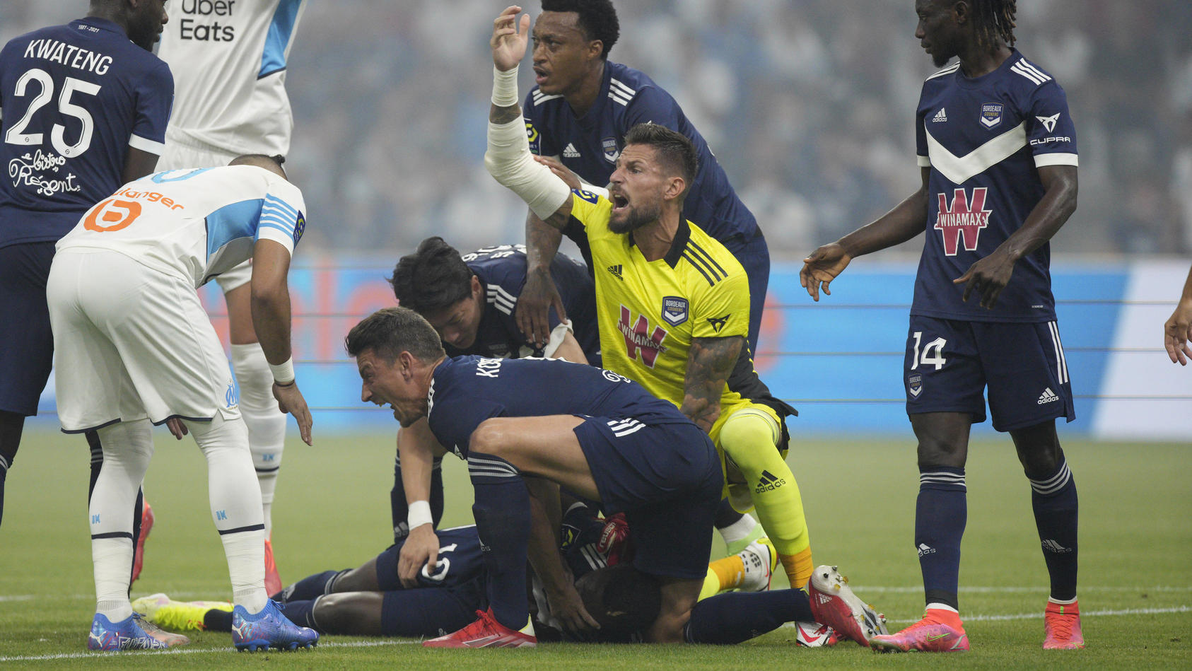 Bordeaux's Samuel Kalu lays on the pitch as players call the medic during the French League One soccer match between Marseille and Bordeaux at the Velodrome stadium in Marseille, southern France, Sunday, Aug. 15, 2021. (AP Photo/Daniel Cole)