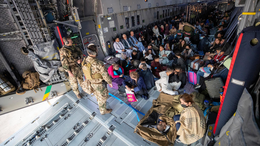 Konflikt in Afghanistan: Menschen sitzen in einem Bundeswehrflugzeug und fliehen vor den Taliban