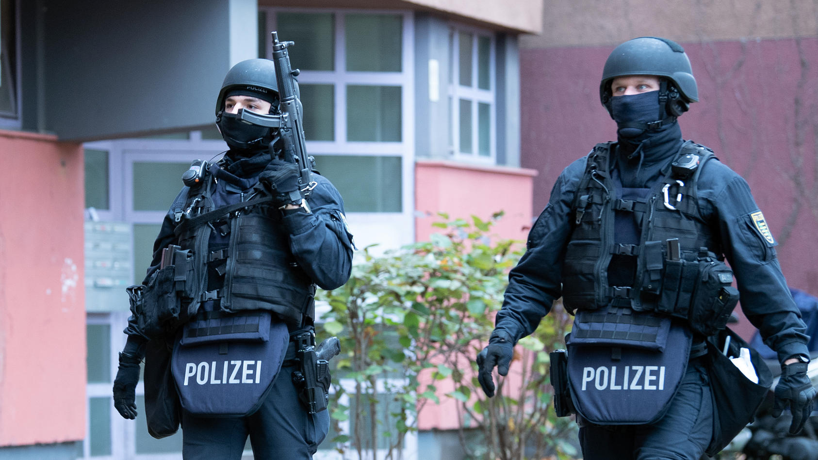 Polizeibeamte gehen zu einem Wohnhaus an der Gitschiner Straße. Dort haben die Beamten am 17. November 2020 drei Tatverdächtige festgenommen.