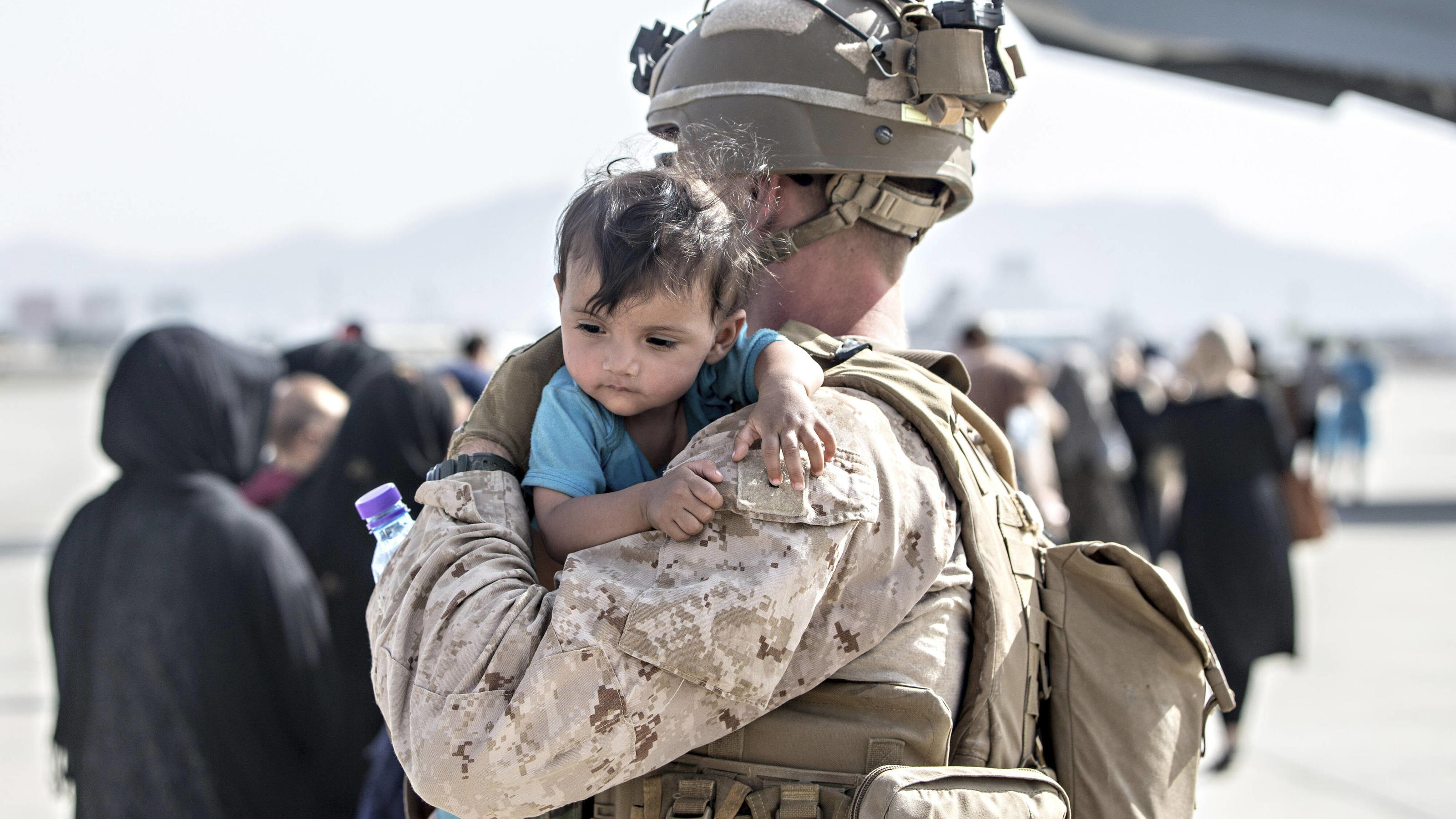 STYLELOCATIONA U.S. Marine with the Special Purpose Marine Air-Ground Task Force-Crisis Response team carries a young Afghan child to an evacuation flight at Hamid Karzai International Airport during Operation Allies Refuge August 21, 2021 in Kabul, 