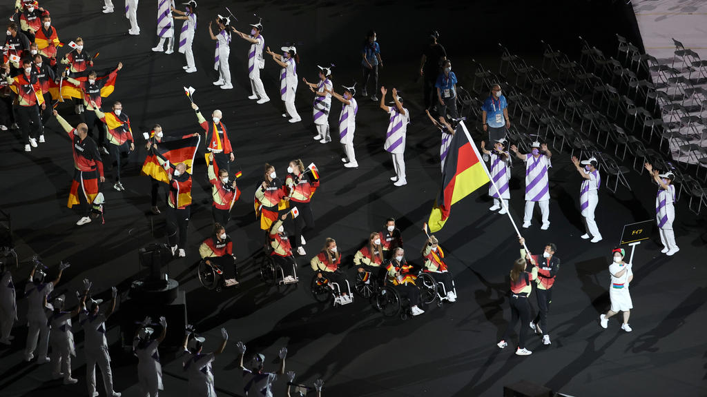 24.08.2021, Japan, Tokio: Paralympics: Eröffnungsfeier im Olympiastadion. Das Team Deutschland kommt zu der Eröffnungsfeier ins Olympiastadion. Die Fahnenträger des Teams Mareike Miller, Rollstuhlbasketball, und Michael Teuber, Paracycling, tragen di