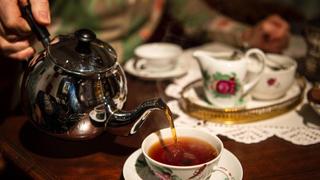 Schwarzer Tee wird bei einer Teezeremonie in eine Tasse gefüllt