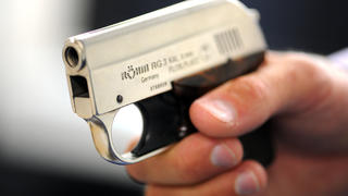 Ein Polizeibeamter hält am 26.09.2012 im Polizeikommissariat 11 in Hamburg eine Pistole der Firma Röhm. Das Diebesgut wurde in Hamburg bei Durchsuchungen in mehreren Wohnungen gefunden. Foto: Daniel Reinhardt/dpa  +++(c) dpa - Bildfunk+++