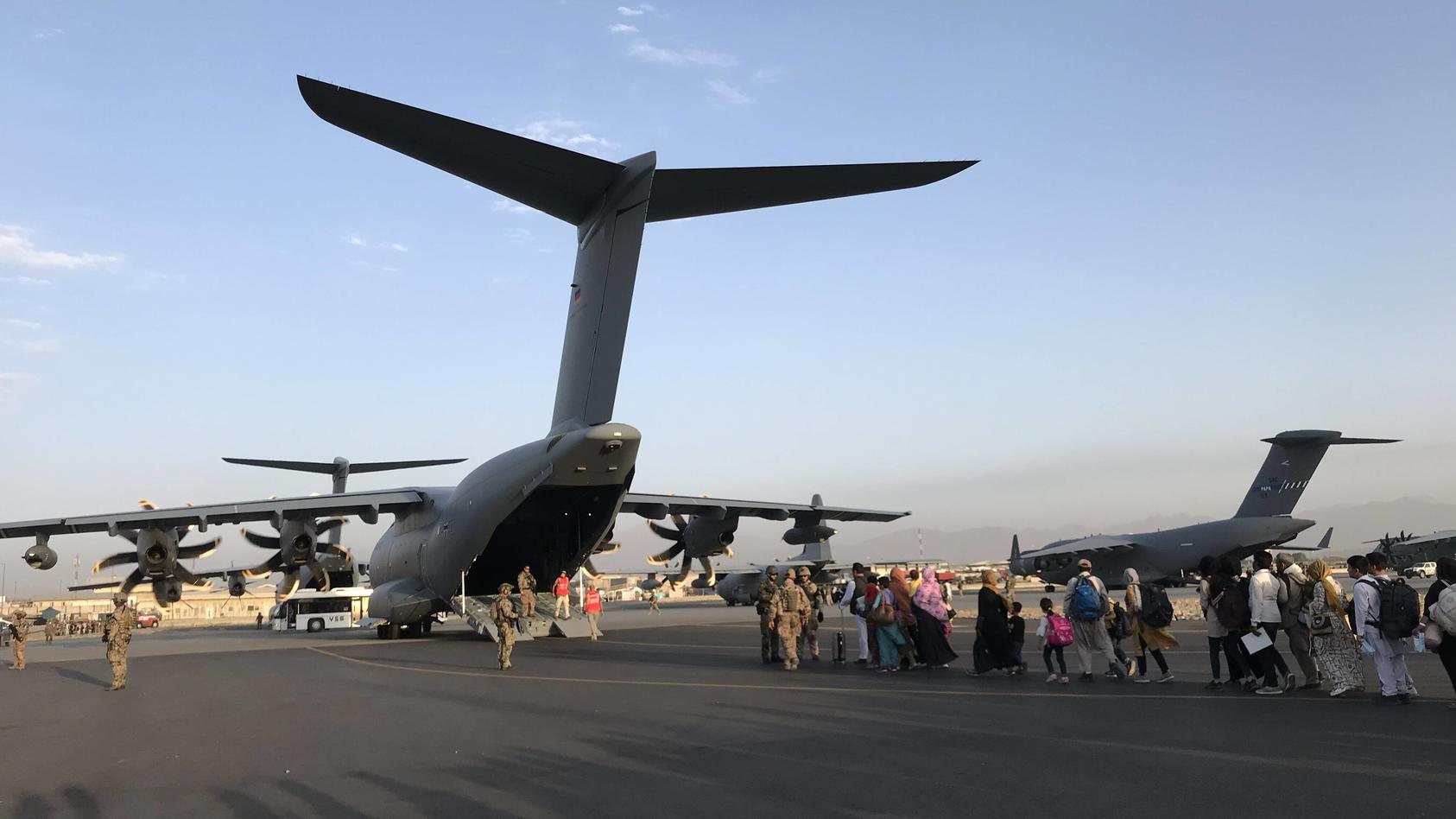  210825 -- KABUL, Aug. 25, 2021  -- People queue up to board a military aircraft of Germany and leave Kabul at Kabul airport, Afghanistan, Aug. 24, 2021.  AFGHANISTAN-KABUL-AIRPORT-EVACUATION xinhua PUBLICATIONxNOTxINxCHN