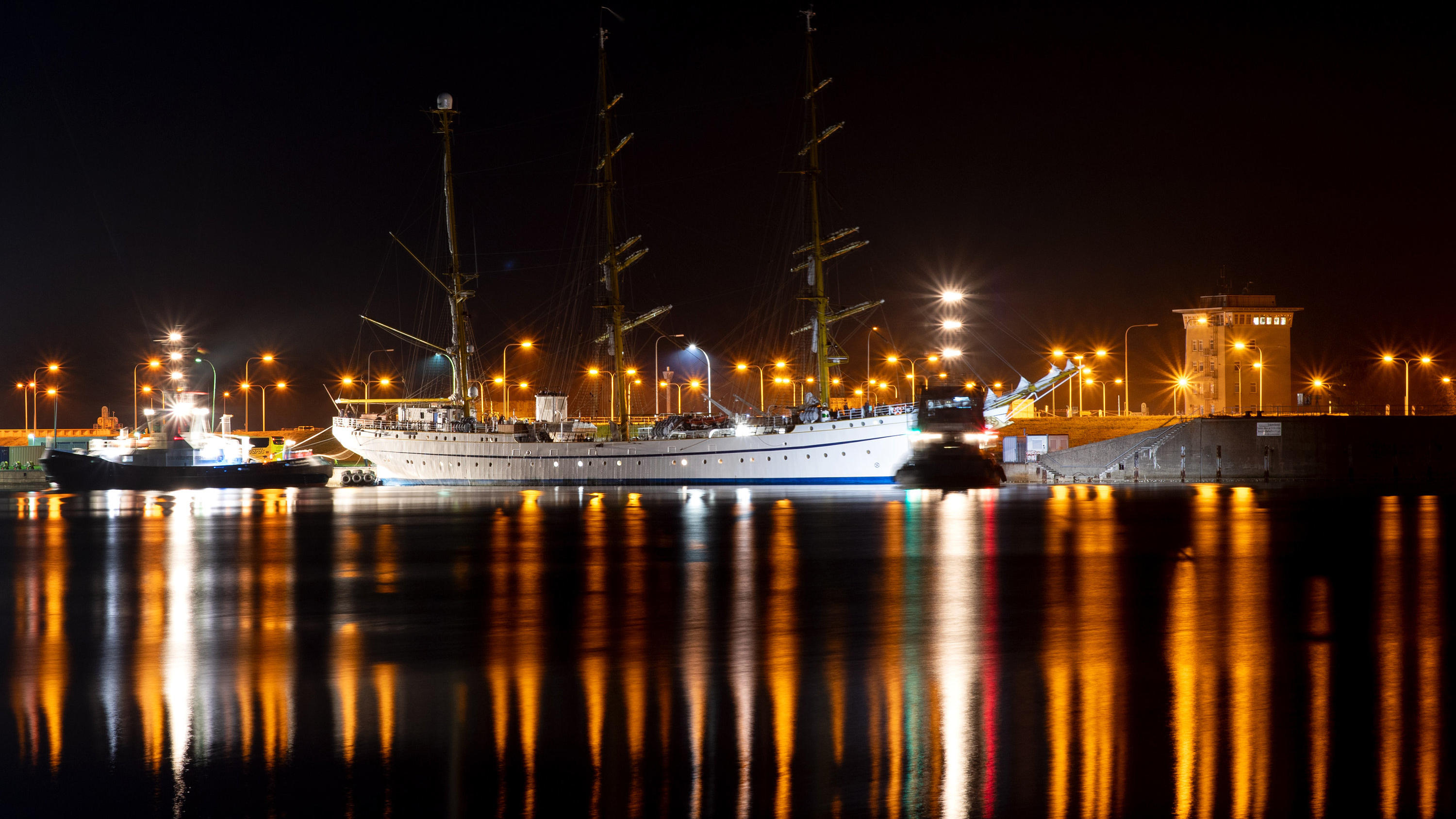 01.09.2021, Niedersachsen, Wilhelmshaven: Das sanierte Marineschulschiff ·Gorch Fock· wird nach einer vorzeitig beendeten Probefahrt in den Hafen von Wilhelmshaven geschleppt (Aufnahme mit langer Belichtungszeit). Das Schulschiff hatte am Mittwochvor