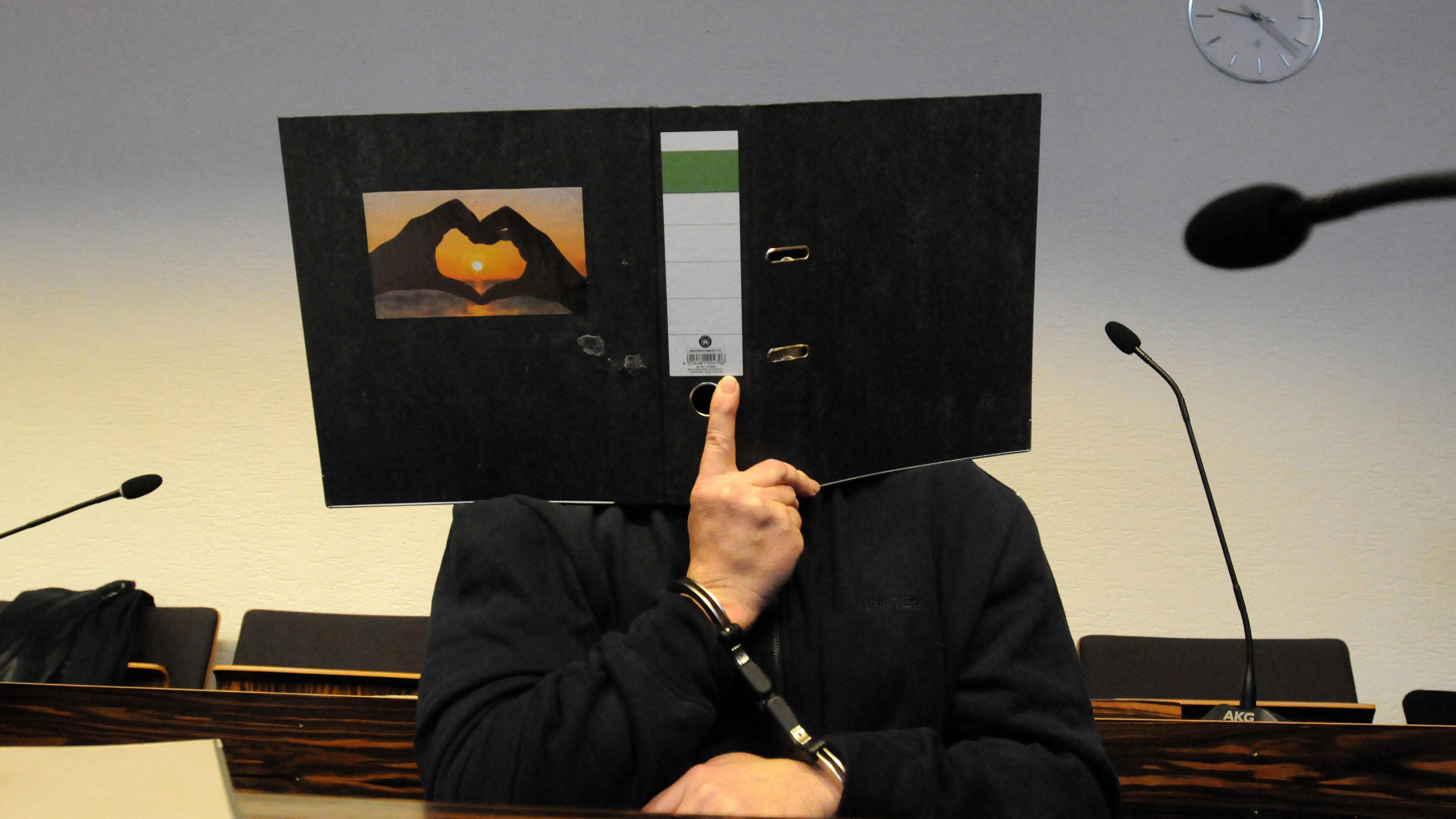 Bernhard H. verbirgt beim Prozess gegen ihn das Gesicht hinter einem Aktenordner.