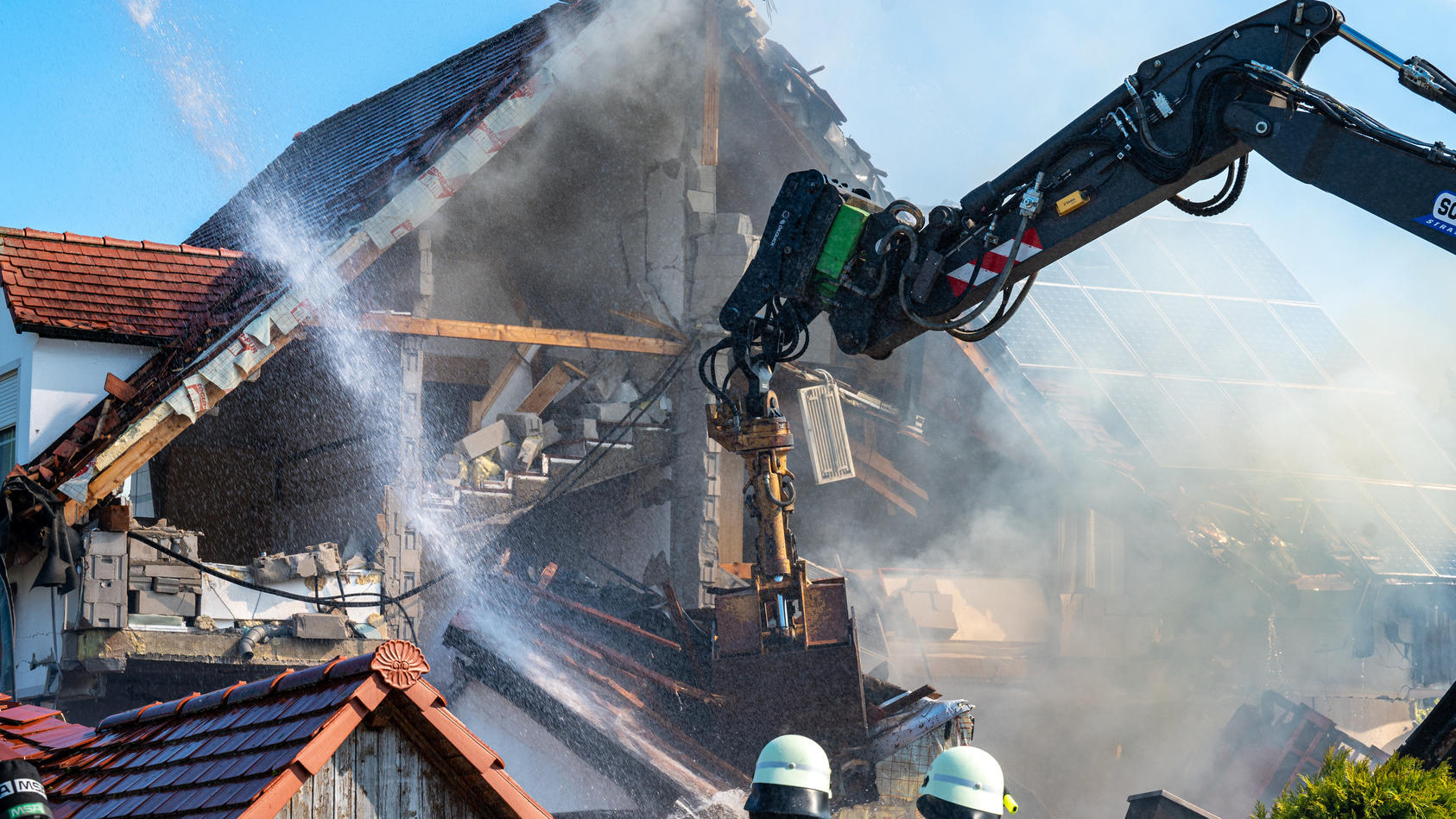 Bayern, Rohrbach: Ein Bagger räumt Teile des eingestürzten Hauses ab und Einsatzkräfte der Feuerwehr sind in der Nähe eines Hauses im Einsatz, in dem es zuvor nach Angaben der Polizei eine Explosion gegeben hatte. Foto: Armin Weigel/dpa