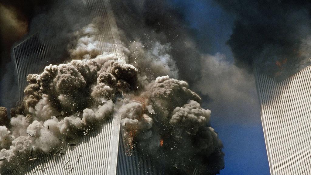 September 11, 2001 - New York, New York, U.S. - The south tower of the World Trade Center, left, begins to collapse in New York Tuesday 9/11. In the most horrifying attacks ever against the U.S., terrorists crashed two airliners into the World Trade