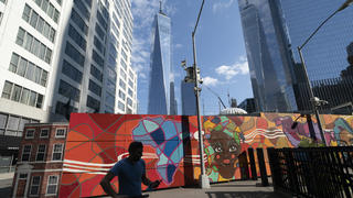 Behind a colorful mural the Port Authority police have a temporary facility at the World Trade Center, Wednesday, Sept. 8, 2021 in New York. A partnership led by Brookfield Properties and Silverstein Properties will develop the site as a 900-foot (270-meter) tower with office and retail space in addition to 1,325 apartments. Two decades after its destruction in the Sept. 11 terrorist attacks, the work to rebuild the World Trade Center complex remains incomplete. (AP Photo/Mark Lennihan)
