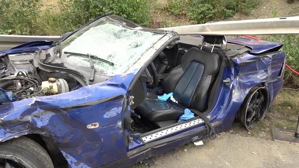 Das Auto kracht unter eine Leitplanke.