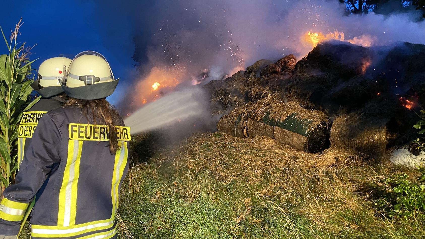 Feuerwehrmänner löschen die brennenden Heuballen. Foto: TVnews-Hessen