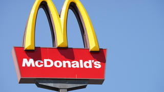 Das Logo einer McDonald's-Filiale mit einem blauen Himmel im Hintergrund.