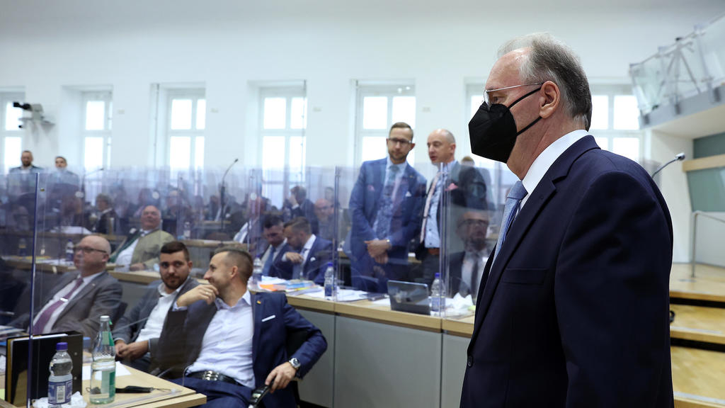 16.09.2021, Sachsen-Anhalt, Magdeburg: Reiner Haseloff (CDU), geschäftsführender Ministerpräsident von Sachsen-Anhalt, betritt vor Beginn des zweiten Wahlgangs den Plenarsaal im Landtag von Sachsen-Anhalt, während im Hintergrund Abgeordnete der AfD-F