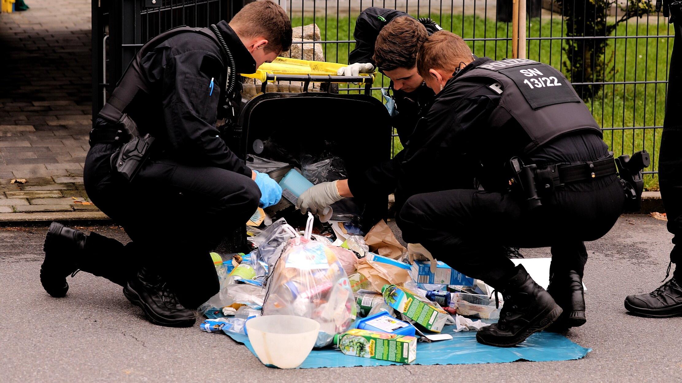 16-Jährige in Sachsen getötet: Polizisten durchsuchen eine Mülltonne.