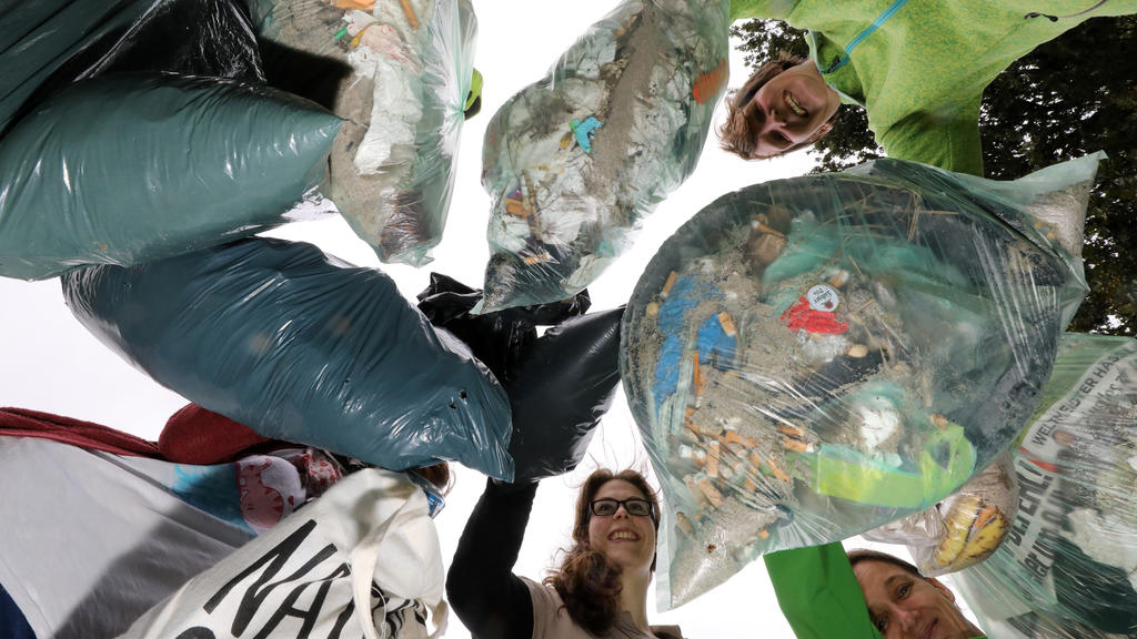 15.09.2018, Mecklenburg-Vorpommern, Kühlungsborn: Teilnehmer einer Müllsammelaktion am Ostseestrand zeigen ihre gefüllten Abfallsäcke. Mehrere Organisationen haben am International Coastal Cleanup Day zu Sammelaktionen an verschiedenen Orten aufgeruf