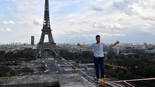 18.09.2021, Frankreich, Paris: Nathan Paulin, Akrobat aus Frankreich, kommt am Theatre National de Chaillot an, nachdem er auf einem Seil vom Eiffelturm über die Seine gelaufen ist. Das Kunstück ist Teil der Veranstaltungen in ganz Frankreich anlässlich der Tage des nationalen Kulturerbes. Foto: Alain Jocard/AFP POOL/AP/dpa +++ dpa-Bildfunk +++