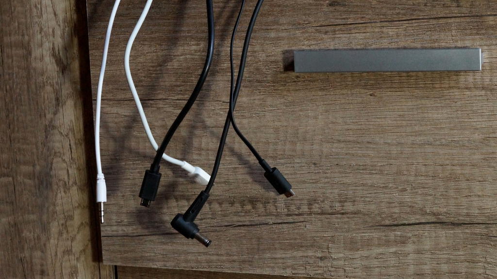 Verschiedene Ladekabel hängen aus einer Schublade heraus.
