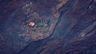 Lava flows surrounded a house following the eruption of a volcano in the Cumbre Vieja national park at El Paso, on the Canary Island of La Palma, Spain September 23, 2021. Ramon de la Rocha/Pool via REUTERS
