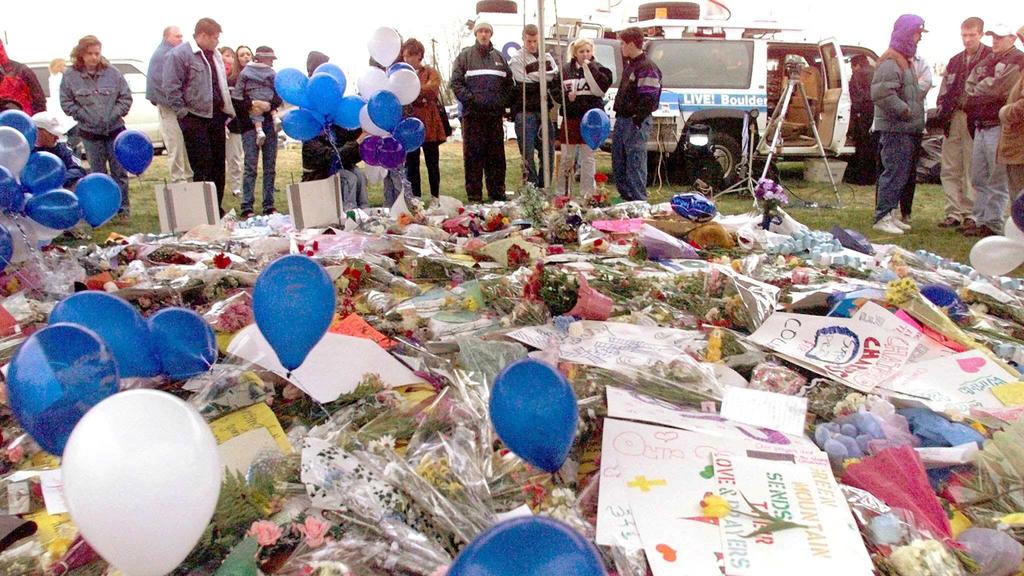 Littleton, Colorado, residents stand near a carpet of flowers, 21 April 1999, mourning the dead at Columbine High School. Two heavily armed Columbine students killed thirteen fellow students and injured more than twenty others in a shooting 20 April,
