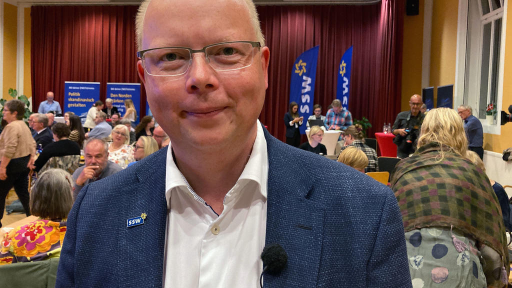 26.09.2021, Schleswig-Holstein, Flensburg: Stefan Seidler, Spitzenkandidat des Südschleswigschen Wählerverbandes (SSW), lächelt auf der Wahlparty der Partei der dänischen Minderheit und der nationalen Friesen in die Kamera. Die Partei ist von der Fün