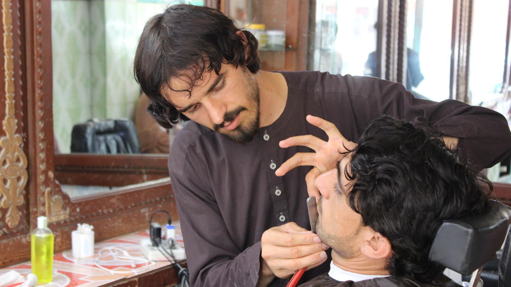 Ein Friseur schneidet einem Kunden in Afghanistan den Bart.
