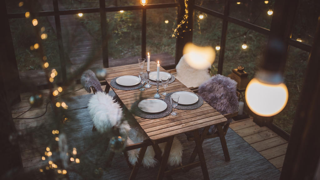 Ein Wintergarten winterlich bzw. herbstlich, mit Lichterketten, geschmückt.