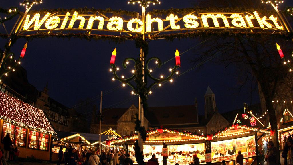 Besucher gehen am Dienstag (18.12.2007) vor der Kulisse des mittelalterlich geprägten Burgplatzes über den traditionellen Weihnachtsmarkt in Braunschweig. Mehr als 130 geschmückte Marktstände laden dort rund um den Dom Heinrichs des Löwen bis zum 28.