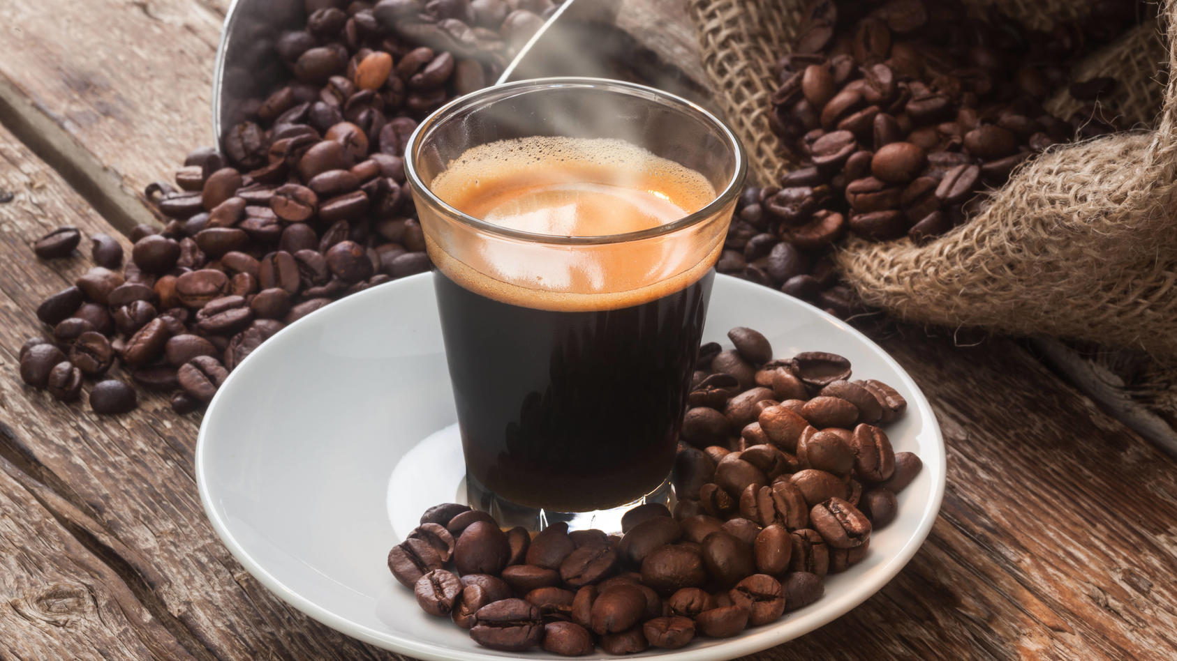 Frisch gebrühter Kaffee vor Kaffeebohnen